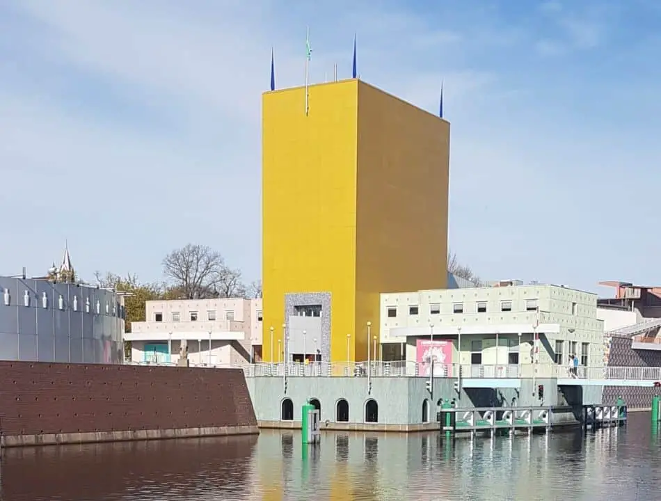The contemporary architecture of the Groninger Museum in Groningen, Netherlands, featuring its distinctive large yellow tower and surrounding waterways. This iconic building is a popular attraction for those looking for things to do in Groningen