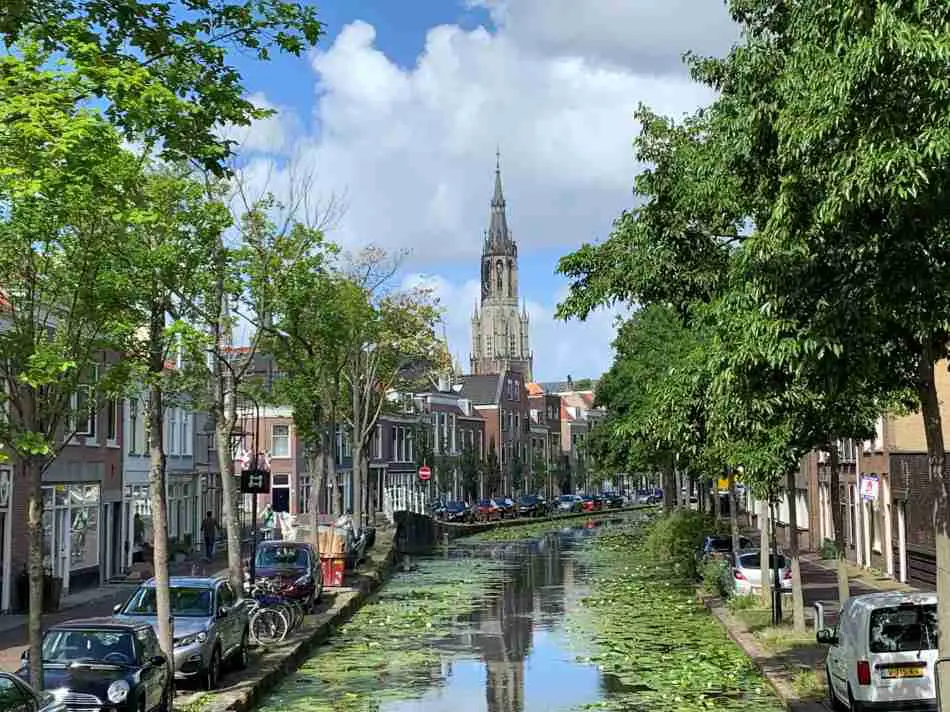 A charming canal in Delft with the New Church in the background on a sunny day