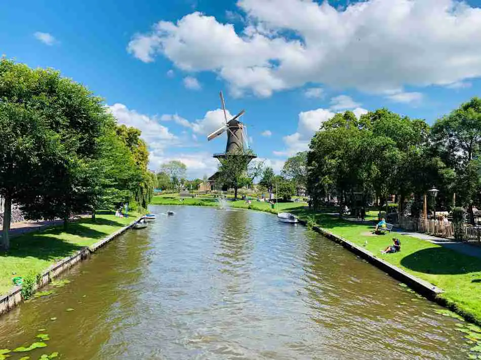 The center of Leiden with a windmill alongside a canal on a sunny day