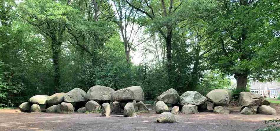 The largest dolmen in the Netherlands near Hof van Saksen, a prehistoric megalithic tomb formed from large boulders nestled in a serene forest setting