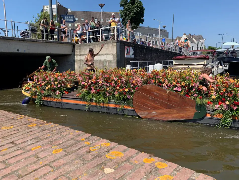 Boat decorated with flowers sailing through Delft in the floating flower parade in 2023